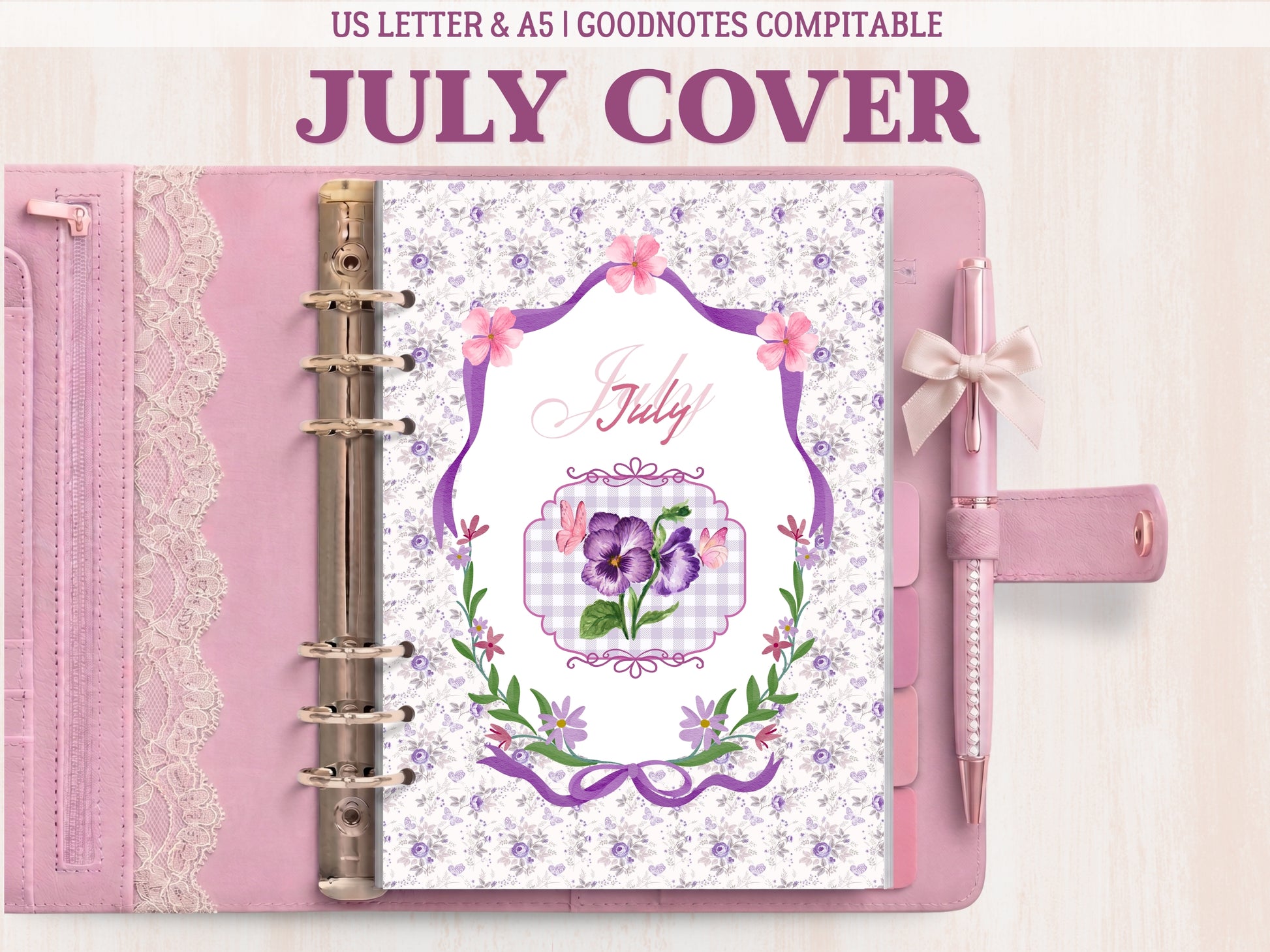A bullet journal cover page for July displayed inside a light pink leather binder with lace details and a matching bow pen. Features an elegant illustration of purple pansies and butterflies inside a frame, surrounded by an intricate purple floral pattern. Labeled as GoodNotes compatible.