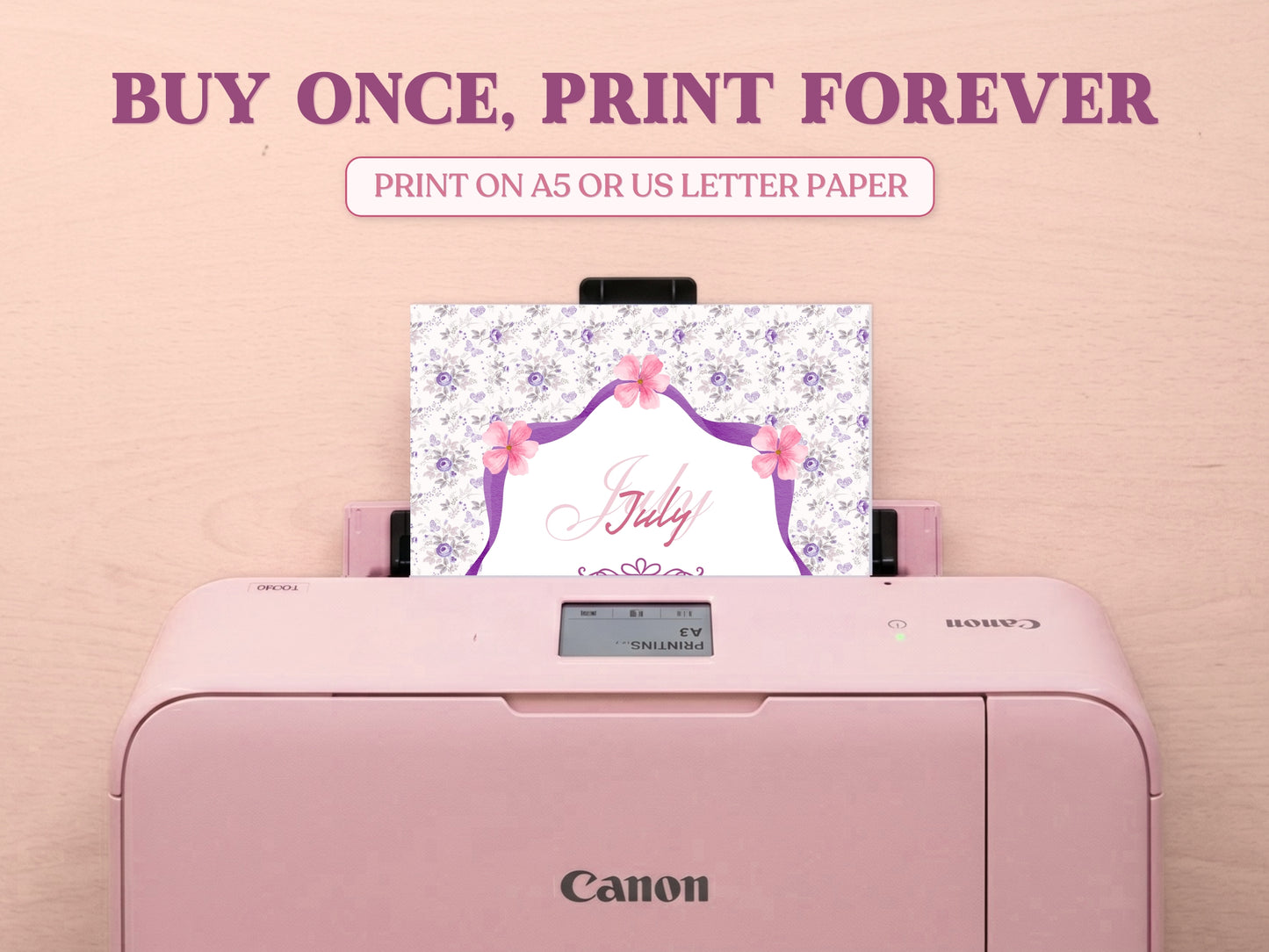 A printable July cover page featuring a purple floral pattern being printed from a pastel pink Canon printer on a wooden desk setup. Includes large decorative text reading 'BUY ONCE, PRINT FOREVER' and 'PRINT ON A5 OR US LETTER PAPER' to highlight its printable features for a bullet journal.