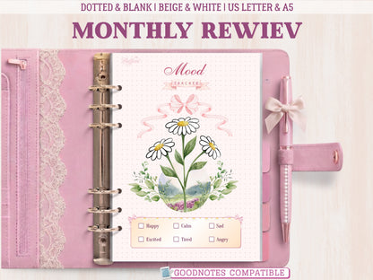 A bullet journal mood tracker page shown inside a pastel pink leather binder with lace detailing and a matching bow pen. Features an aesthetic illustration of three daisy flowers with green leaves, a pink ribbon bow, a dotted background, and a mood key at the bottom. Labeled as GoodNotes compatible.