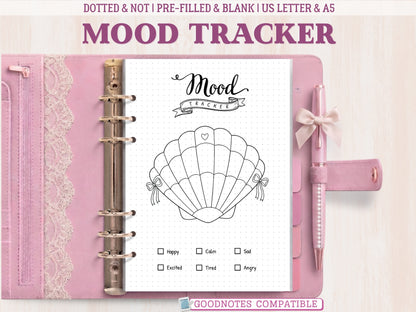 A minimalist seashell mood tracker page for a bullet journal displayed inside an open pink leather binder decorated with lace. Features a black and white line-art seashell with 31 numbered sections to color and a mood key at the bottom. Labeled as GoodNotes compatible.