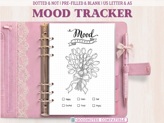 A bullet journal mood tracker page featuring a beautiful tulip bouquet line-art design, displayed inside an open pink leather binder decorated with lace. Includes a mood key at the bottom. Labeled as GoodNotes compatible.