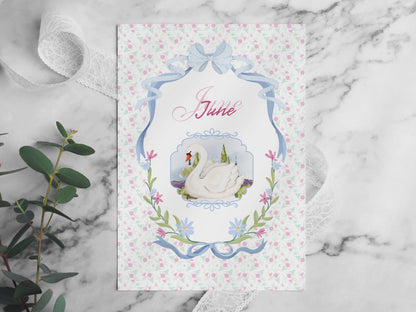 A video flip-through of the June Bullet Journal pages placed on a white marble table. The video showcases various layouts including the swan cover, habit trackers, and workout challenges in a soft pink aesthetic. Surrounded by decorative elements like eucalyptus, lace, and pearls in bright, natural light.